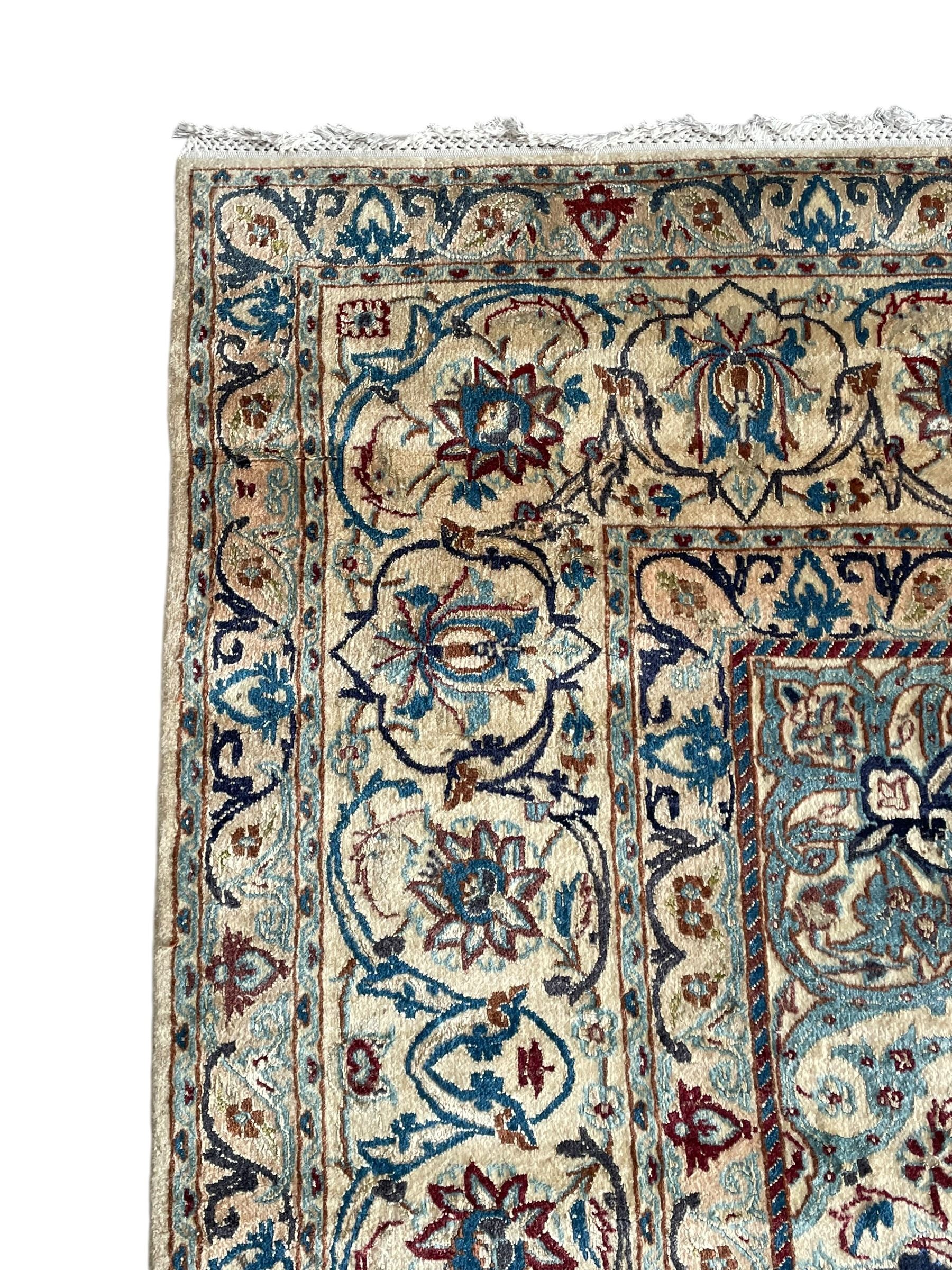 Persian Nain blue and ivory ground rug, wool with silk inlay, overall arabesque design, central medallion surrounded by interlacing and scrolled leafy branches and palmettes, the scrolling border decorated with stylised plant motifs, within guard stripes