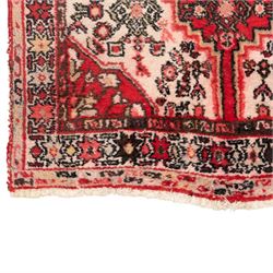Persian crimson ground runner rug, the field decorated with repeating Herati motifs around an ivory pendant medallion, stepped ivory spandrels with stylised floral ornament, enclosed by a dark ground star border and narrow guard stripes
