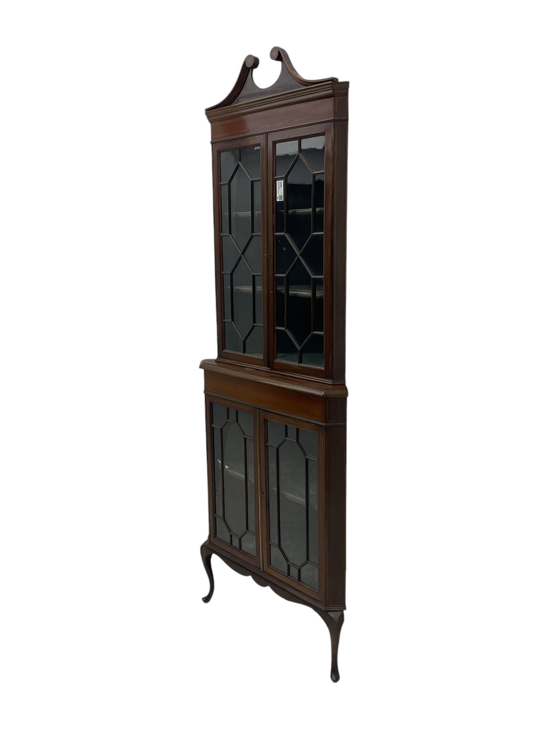 Edwardian mahogany corner display cabinet, scrolled swan neck pediment over astragal glazed doors, fabric lined interior, on cabriole feet 