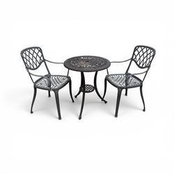 Circular cast aluminium garden table and pair of armchairs chairs with lattice backs in a ...