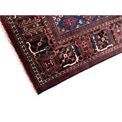 Persian Joshaghan crimson ground rug, stepped lozenge medallion surrounded by repeating foliate lozenge motifs, the border decorated with stylised plant motifs, within geometric guard stripes