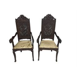 Pair early 20th century Indian Kashmiri hardwood armchairs, the cresting rail and back decorated with carved and pierced dragon, carved with traditional symbols and script, the arms carved with foliage and terminate into dragon masks 