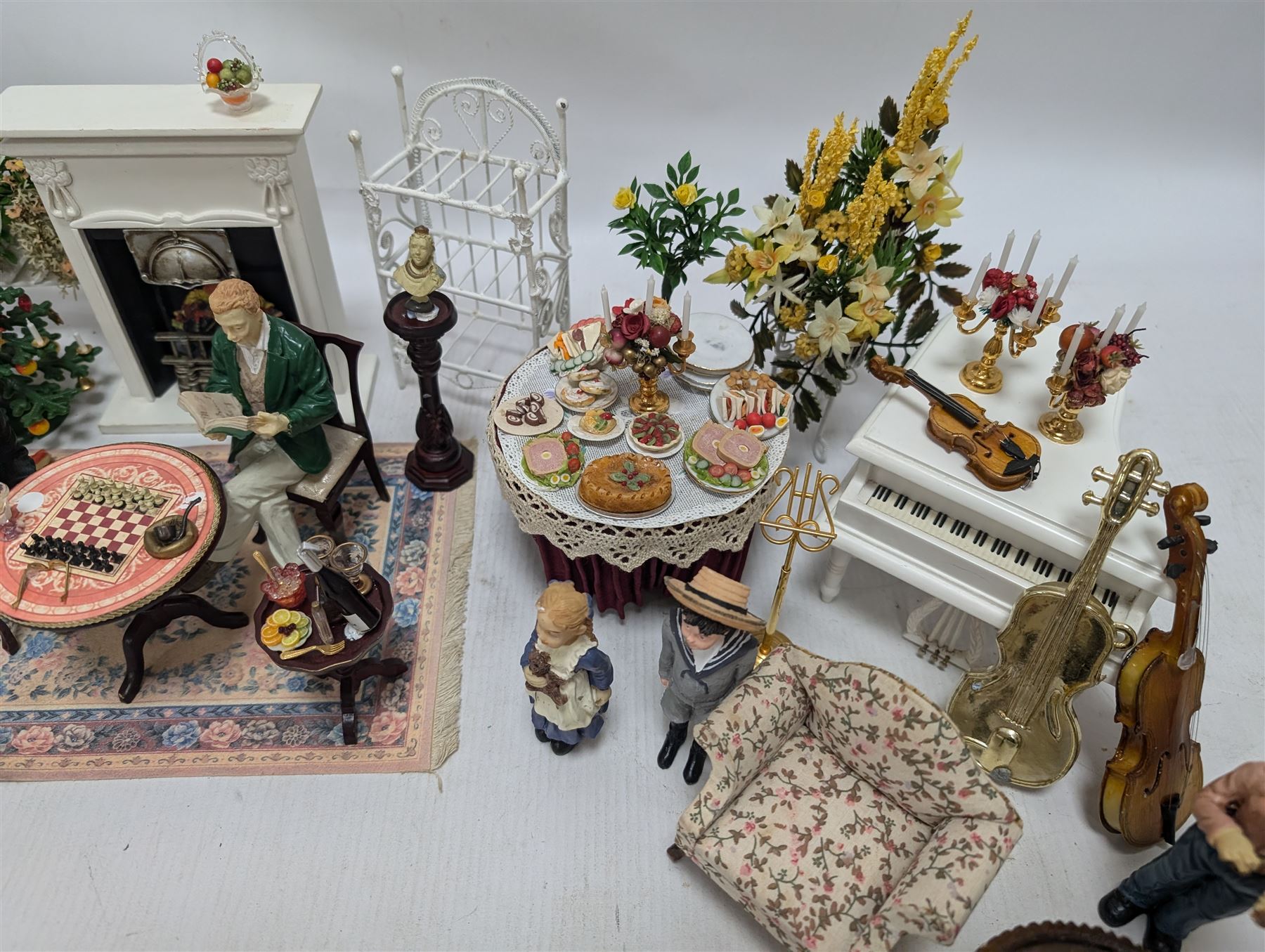 Dolls house furniture, including pianos, fireplace, plants, flower arrangements, tables, chairs, six figures and a collection of instruments and other accessories