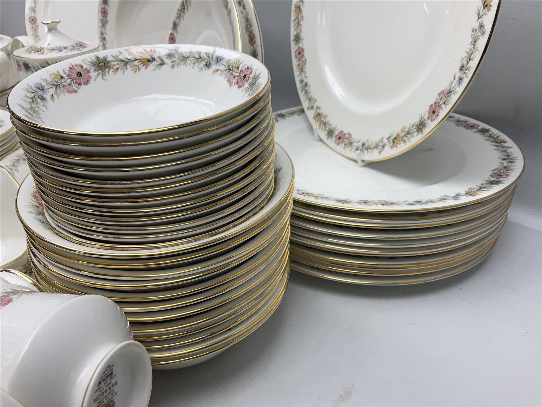 Royal Albert Paragon tea and dinner service for twelve decorated in the Belinda pattern, comprising fourteen saucers, twelve teacups, thirteen side plates, teapot, sauce boat and stand, salt and pepper shakers, two jugs, sucrier, twelve dinner plates, twelve smaller plates, two lidded tureens, twelve bowls, twelve smaller bowls, cake plate, oval plate and oval dish (100)