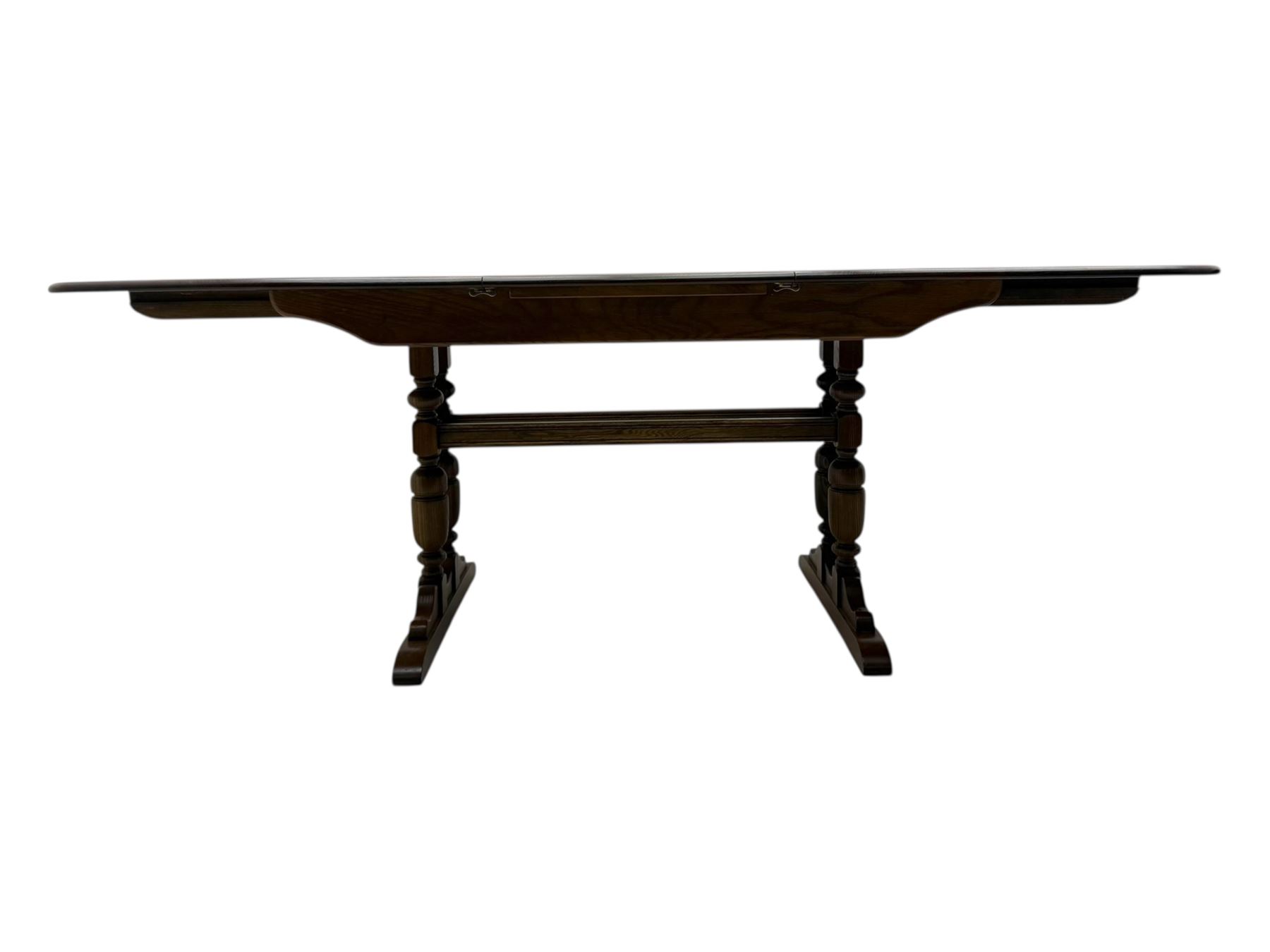 Ercol - late 20th century oak refectory dining table, rectangular top with rounded corners and central extending leaf, raised on turned baluster supports united by a stretcher (Extended 200cm)