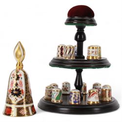 Collection of fifteen Royal Crown Derby thimbles upon an ebonised display stand, together with Royal Crown Derby candle snuffer in Imari pattern 1128