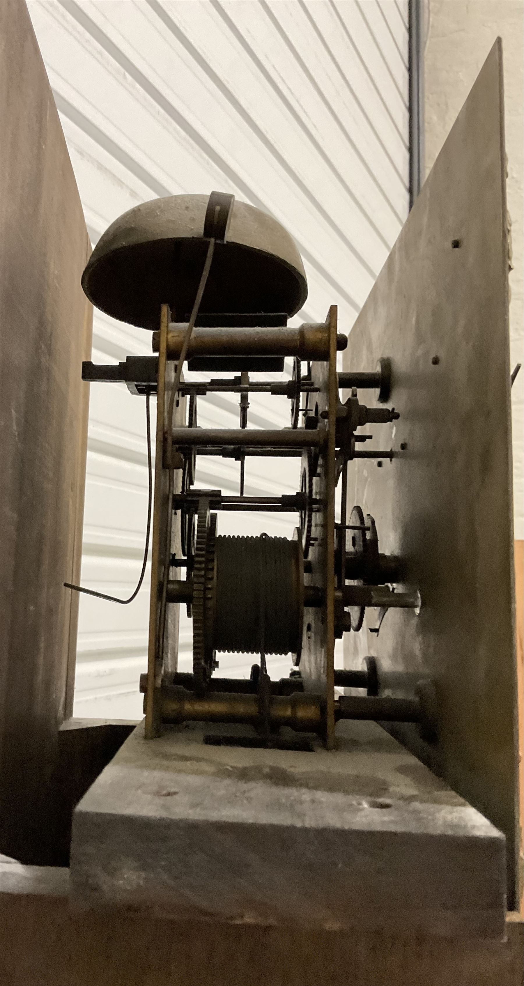 8-day oak longcase clock - in an early 18th century styled case with a caddy top, square hood door with barley twist columns, long carved trunk door on a conforming plinth with an applied skirting base, square brass dial with an engraved centre, silvered chapter and spandrels, 19th century rack striking movement, striking the hours on a bell. With weights and pendulum.