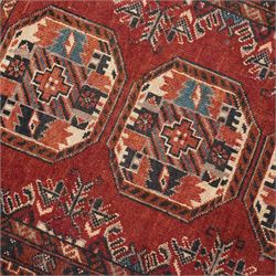Afghan red ground rug, the field decorated with stylised plant motifs, within multiple borders (137cm x 105cm); together with a Caucasian red ground rug decorated with three Gul motifs (123cm x 85cm)