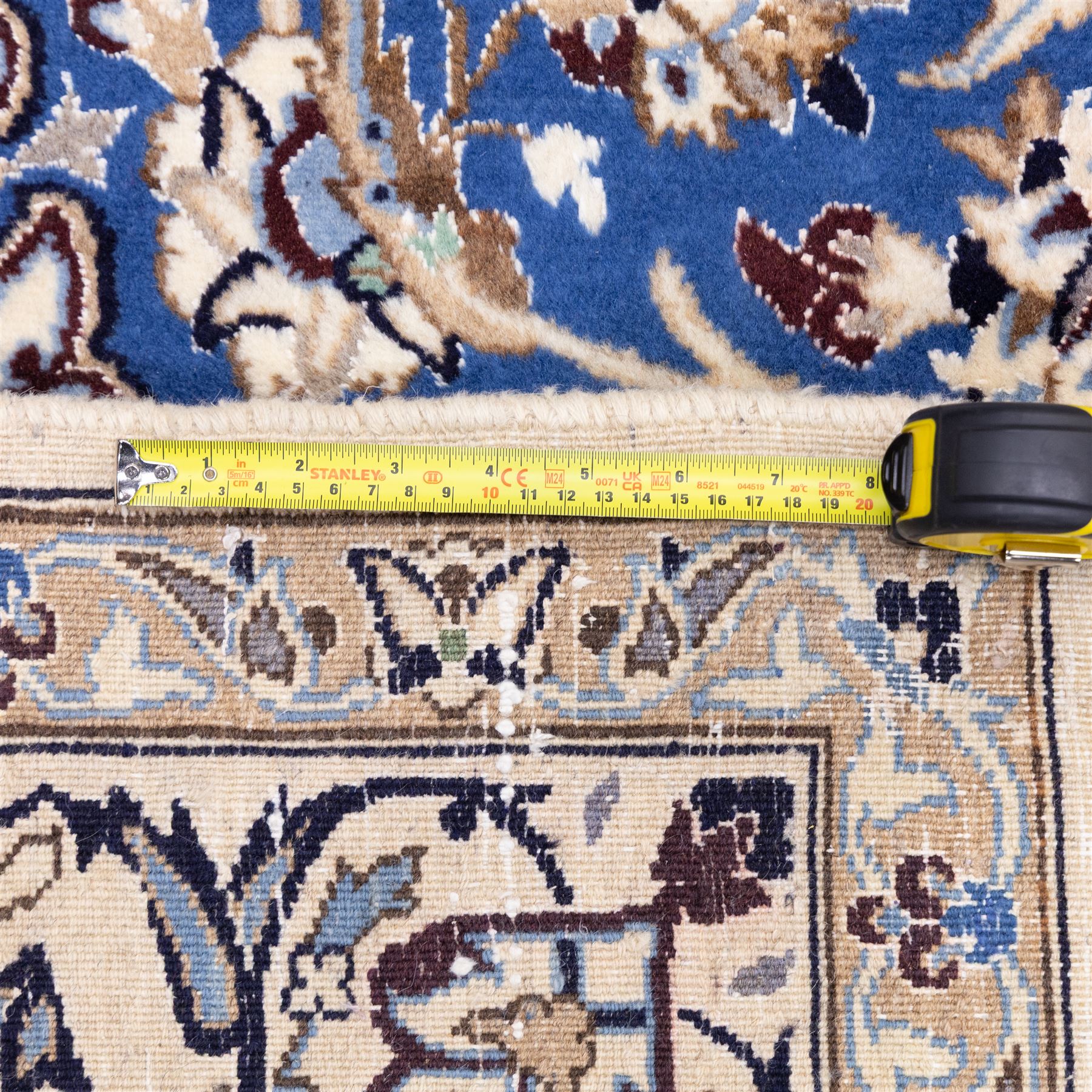 Central Persian Nain hand-knotted rug, soft blue field with central medallion with finely drawn scrolling palmettes and floral tendrils, with ivory spandrels, enclosed by a floral meander border flanked by multiple guard stripes with cotton fringe ends 