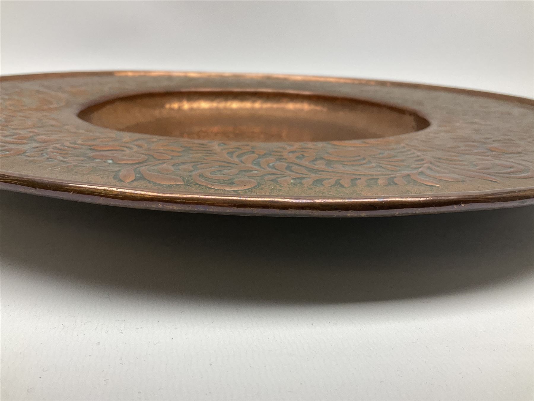 Arts and Crafts Keswick School of Industrial Arts copper charger, decorated with planished centre and repousse scrolling foliate tendrils to rim, D44cm