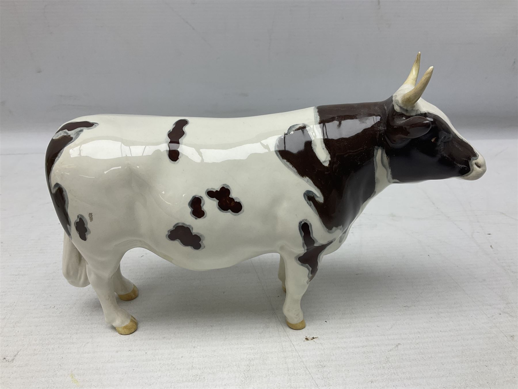 Five Beswick figures of cattle Comprising Ayrshire Bull Ch Whitehill Mandate, no 1454B, three Ayrshire Cow Ch Ickham Bessie, no 1350 and Ayrshire Calf, no 1249B, all with printed marks beneath