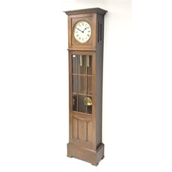 Early 20th century oak longcase clock, projecting cornice over plain dial with Roman numerals, the trunk enclosed by astragal glazed door with panel, twin weight driven eight day movement striking the hours and half on coil