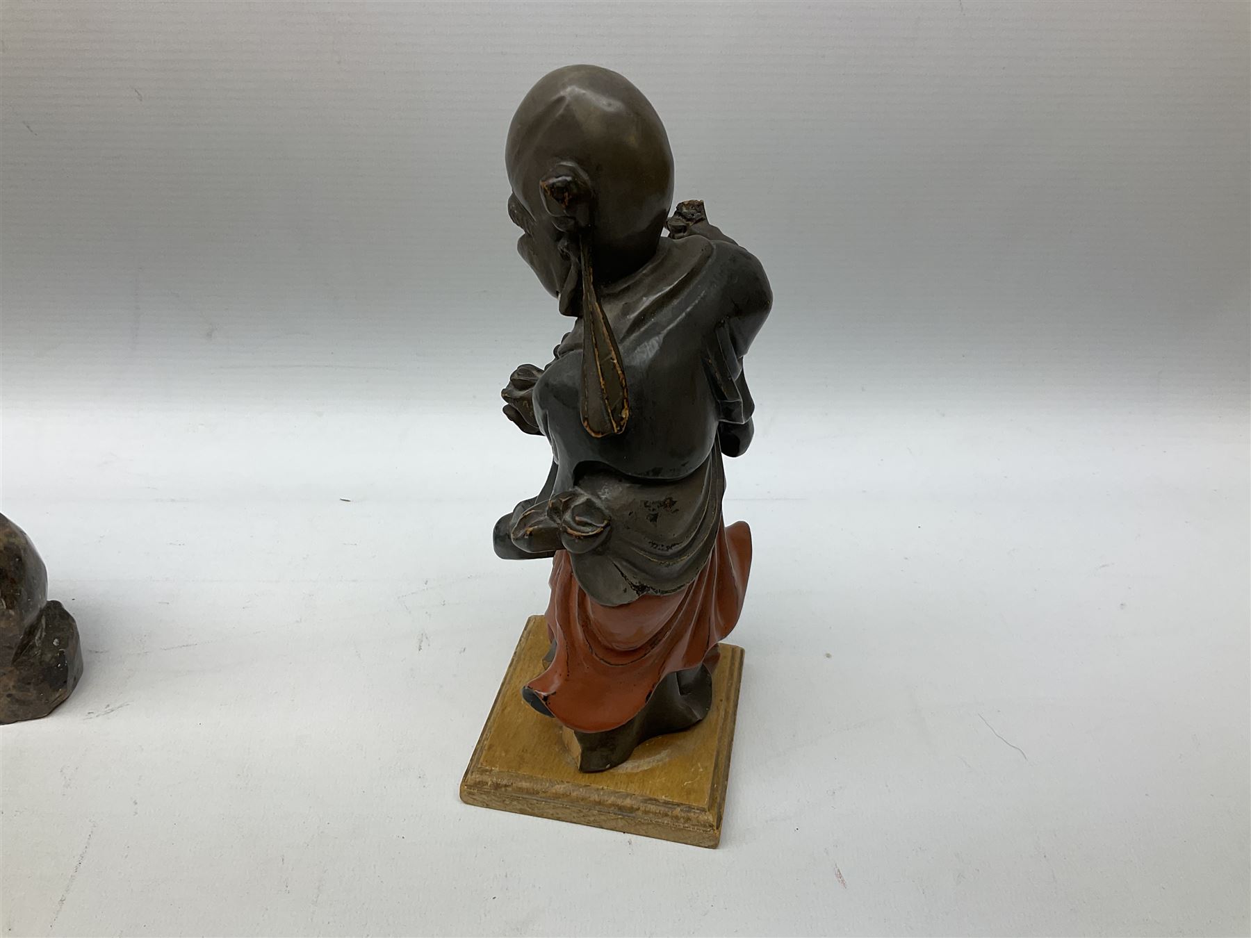 Three soapstone carvings, to include three toed dragon example, carved example with monkeys and another similar, together with carved wood figure, largest L29cm 