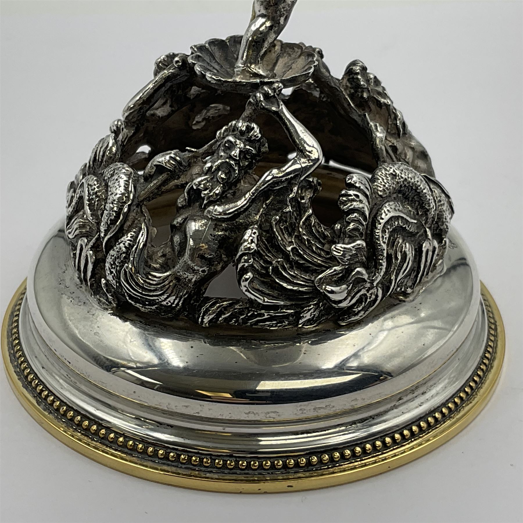 Modern limited edition silver mounted nautilus shell cup, no. 42/150, the pearlescent shell cup with silver-gilt strapwork to rim, upon a stem modelled as a putto supporting a gilt cornucopia and circular domed foot depicting Poseidon amongst swirling waves, hallmarked by St James House Company, London 1980,  H17.5cm
