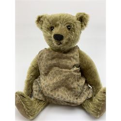 Early 20th century German Steiff teddy bear c1910 with wood wool filled humped back mohair body, swivel jointed head with black boot button eyes and horizontally stitched black nose and mouth, FF metal button to left ear, jointed elongated limbs with felt paw pads and black stitched claws H13