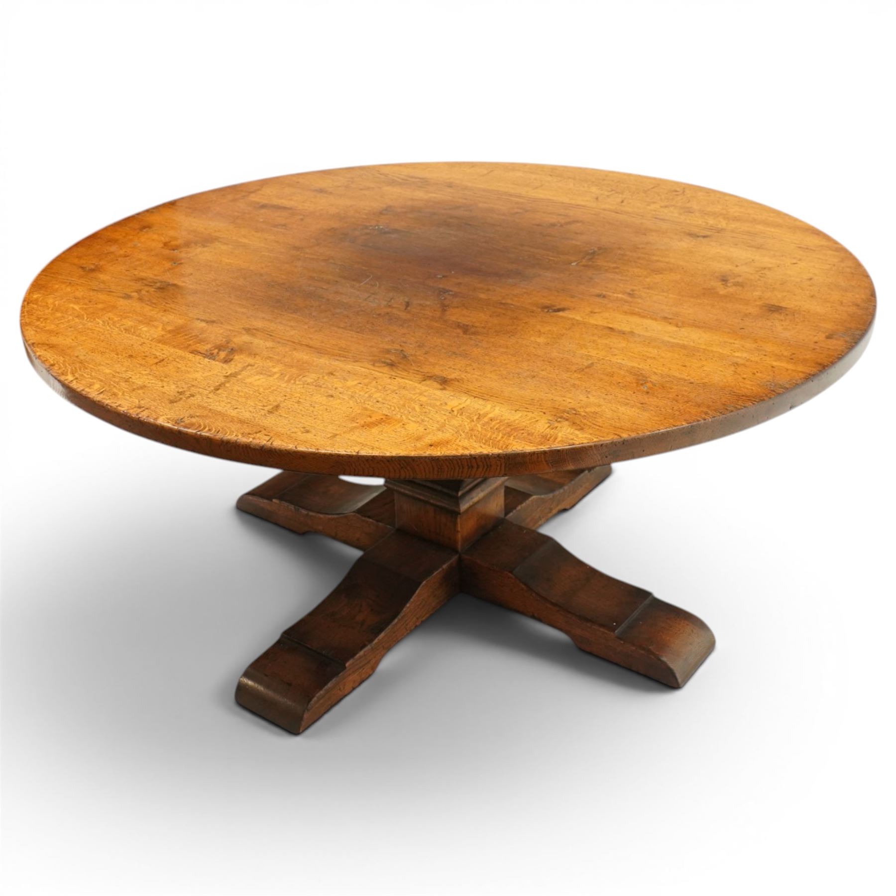 Early 20th century oak centre table, the large circular top raised on a squared and turned baluster pedestal, terminating to four splayed supports