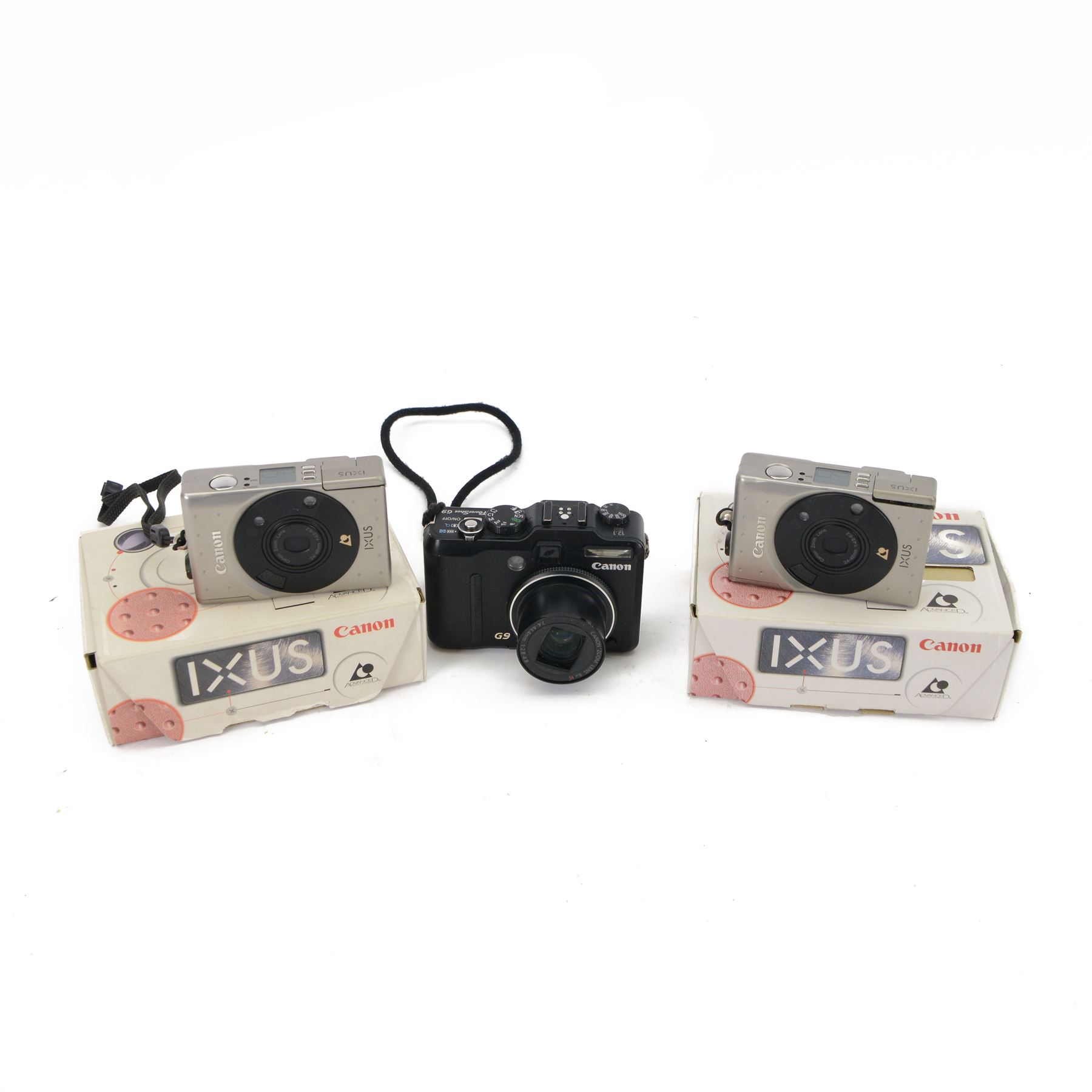 Two Canon Ixus IX240 compact digital cameras, both boxed, together with a Canon PowerShot G9 compact digital camera with a Canon 7.4-44.4mm 1:2.8-4.8 zoom lens (3)