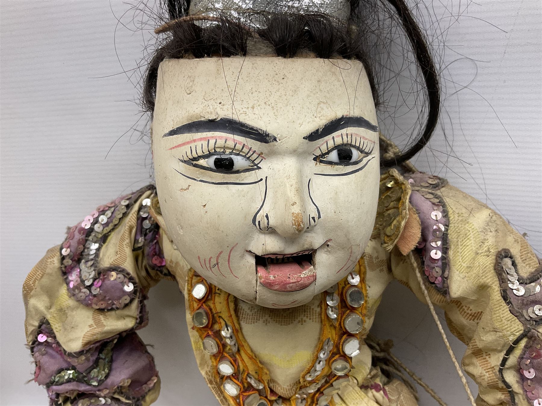 Large string puppet, probably Thai or Burmese, modelled as a woman in traditional costume embellished with sequins, the painted head with articulated mouth, the wood body and hands jointed, L70cm