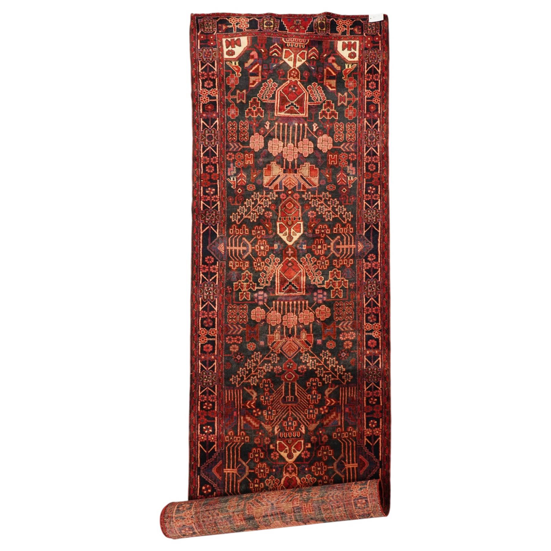 Persian Hamadan runner rug, the indigo ground decorated with stylised flowering plants and geometric motifs in crimson, rose and ivory, enclosed by an indigo flowerhead border and narrow red guard stripes
