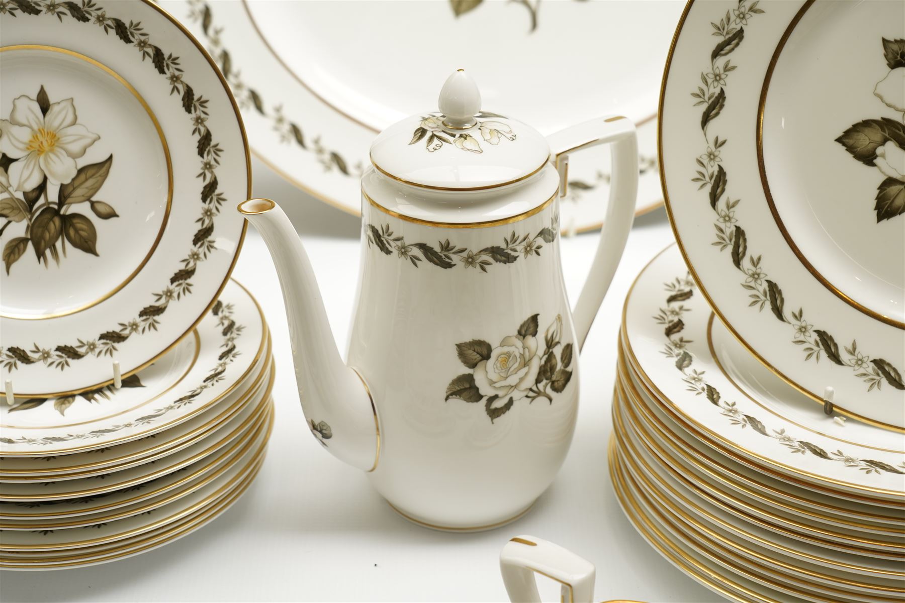 Extensive Royal Worcester Bernina pattern table service comprising thirteen dinner plates, twelve dessert plates, nine two handled soup bowls and stands, twelve side plates, three vegetable dishes and covers, pair of sauce boats and stands, two graduated oval meat plates, eleven tea cups, fourteen saucers, sixteen tea plates, coffee pot and eight coffee cups and saucers, (113 pieces) 