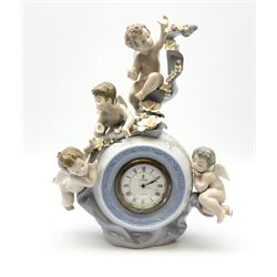 A Lladro mantel clock modelled as a globe with inset clock, surmounted by four putti and floral garlands, with blue printed mark and impressed 5973 beneath, H29cm.