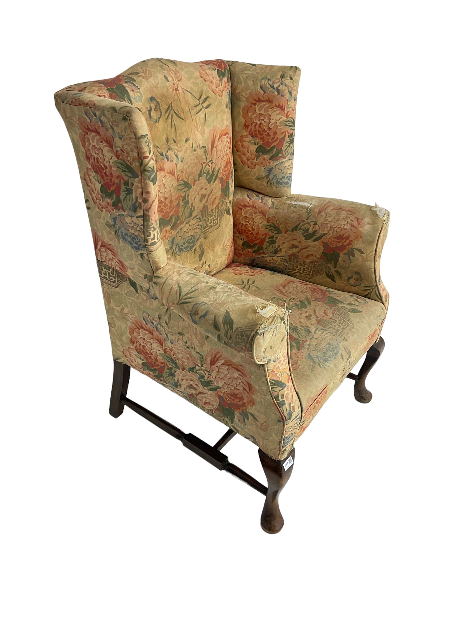 Early 20th century Georgian style wingback armchair, upholstered in floral fabric with sprung seat, walnut frame with front cabriole supports