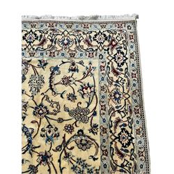 Persian ivory ground rug, the  large floral medallion within a field decorated with scrolling branches with clusters of flower heads, the matching ivory border with palmette motifs and interlaced scrolling