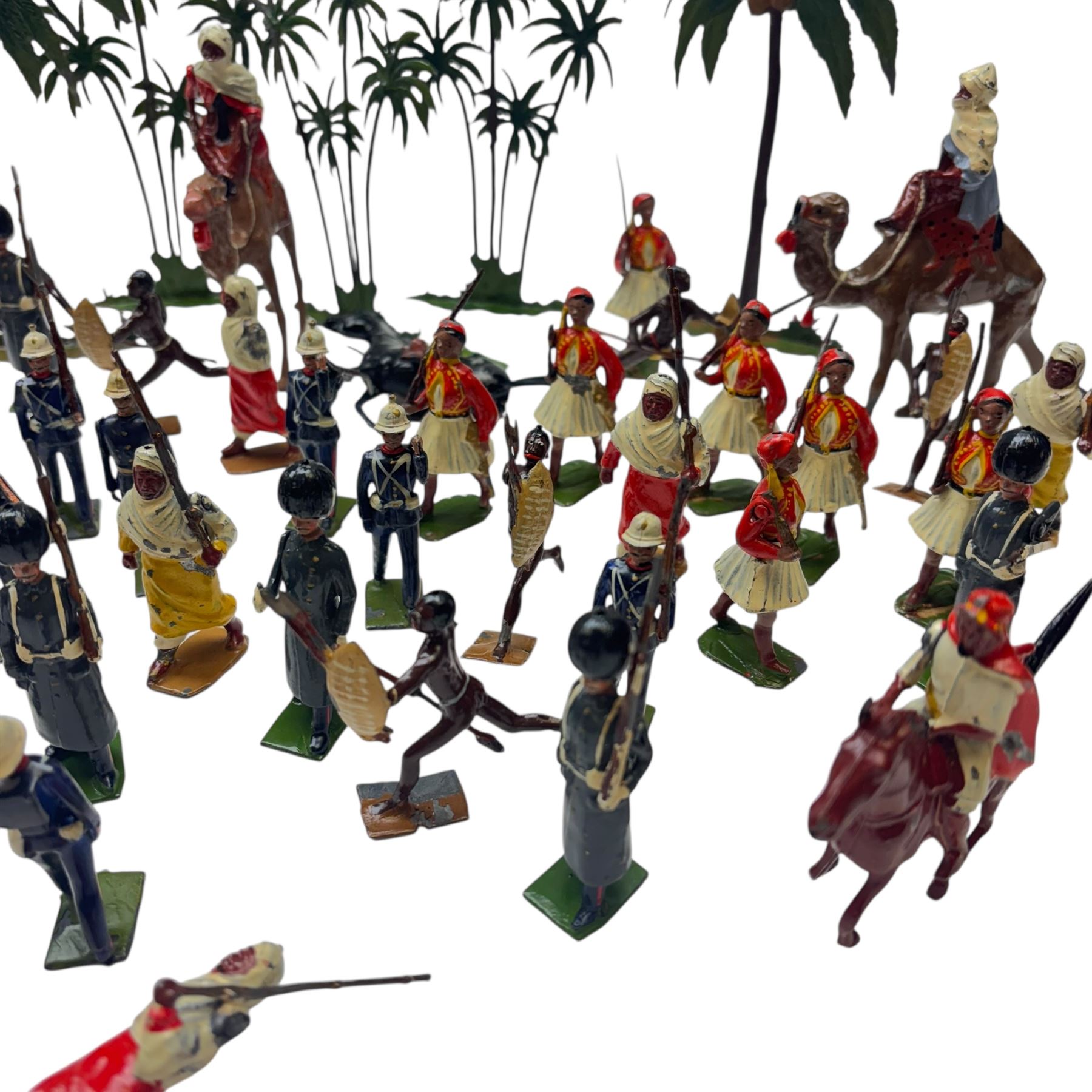 Britains lead figures circa 1930, comprising eight 'Grenadier Guards', seven 'Royal Marines', eight pre-war 'Greek Evzones', eight 'Zulu Warriors', six marching 'Bedouin Arabs' and two on horseback, five 'Arabs of the Desert' including two on horseback and three mounted on camels and five palm trees