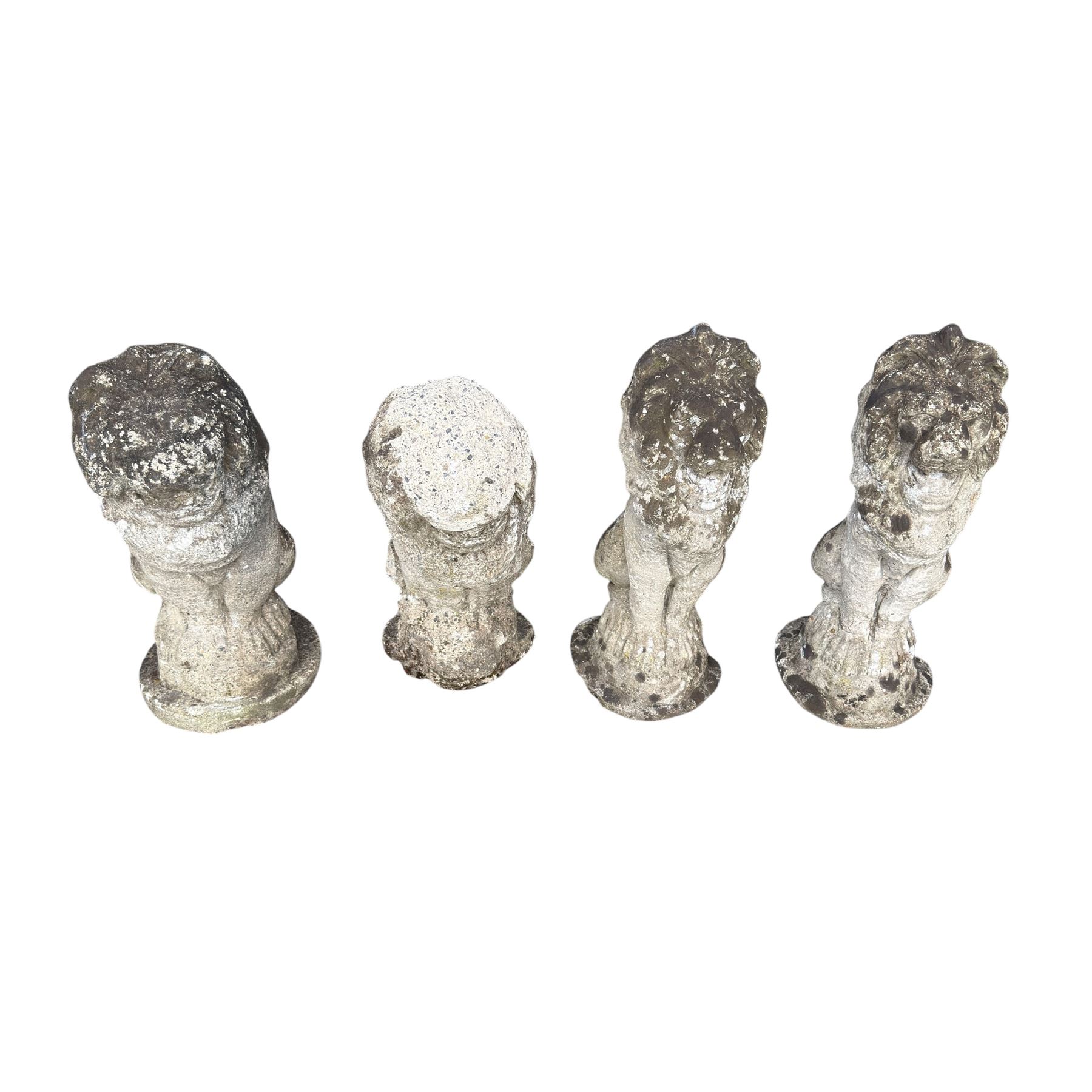 Four weathered cast stone lions in seated poses