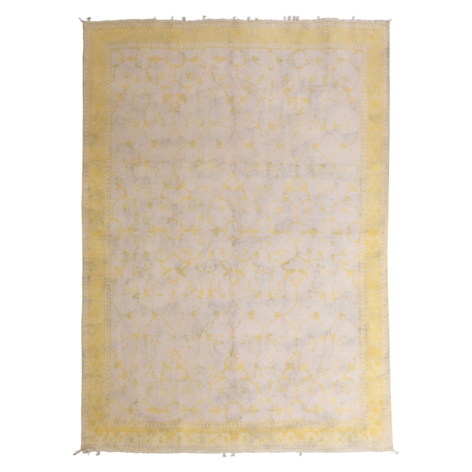 Tibetan wool rug, decorated with a pale cream ground and yellow all-over foliate design, enclosed by a broad yellow floral border and narrow inner guard band