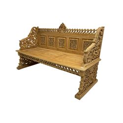 Carved teak garden bench, the cresting rail carved and pierced with foliate design, shaped arms and end supports decorated with scrolling foliage and flower heads