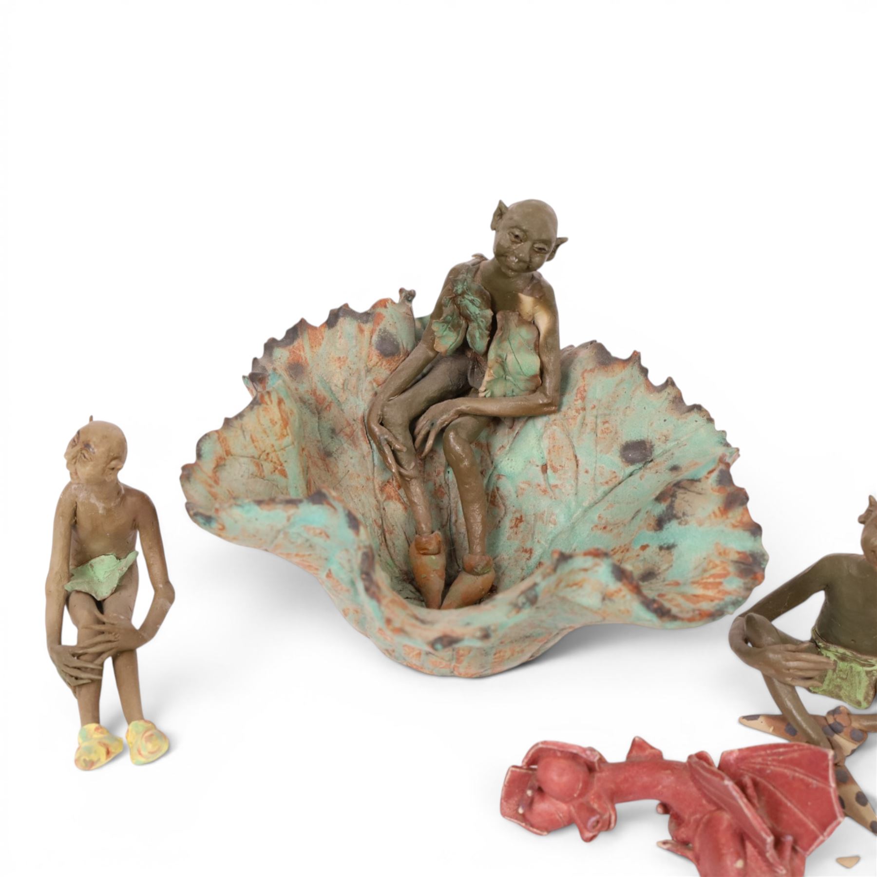 Joan Bideau dish, modelled as a leaf with seated goblin figure, together with three others  and studio pottery dragon by Jane Tudor