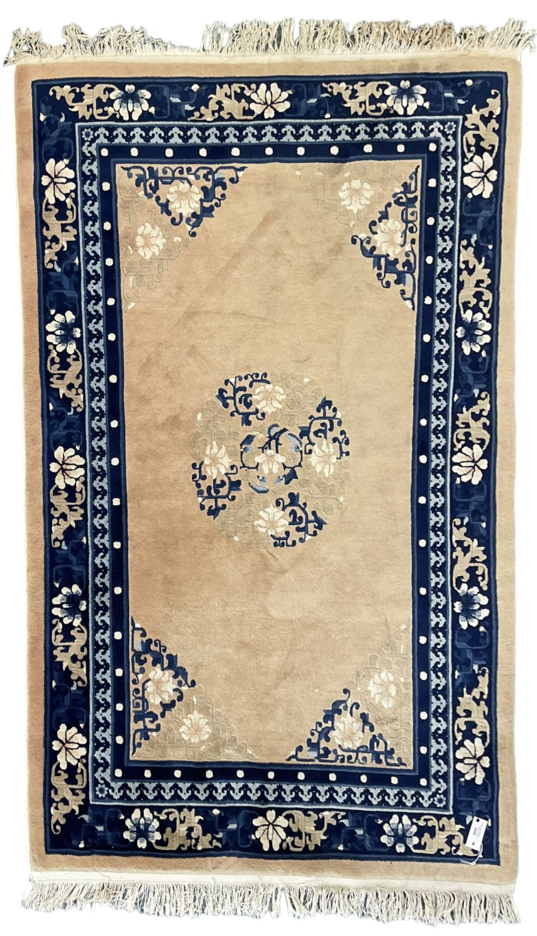 Chinese washed woollen peach ground rug, indigo borders and trailing foliate decoration, central medallion decorated with flowerheads 