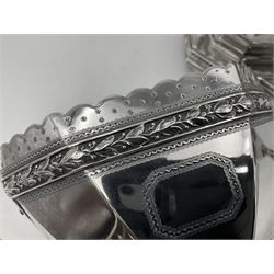 Victorian silver four piece tea service, comprising teapot, teapot stand, twin handled open sucrier and milk jug, each of octagonal form with foliate bud border and engraved decoration including crest to canted panels, and vacant panels, the teapot with ivory finial to the hinged cover and later wooden handle, hallmarked Edward Barnard & Sons Ltd, London1896, teapot including finial H15cm, milk jug including handle H16cm, teapot stand W11.5cm

This item has been registered for sale under Section 10 of the APHA Ivory Act