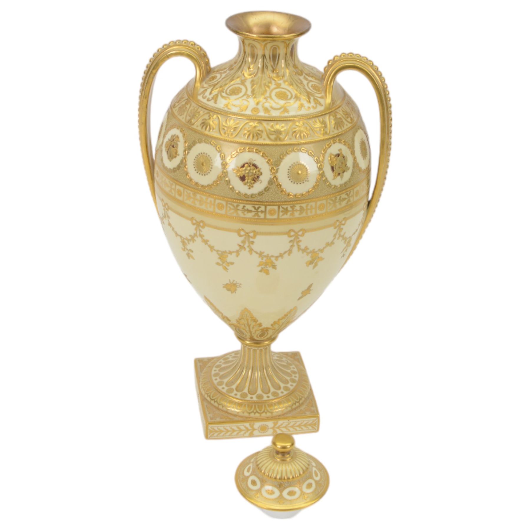 Royal Crown Derby twin handled vase and cover, circa 1886, decorated with raised and tooled gilt borders of foliate scrolls and husk swags upon a cream ground, H38cm