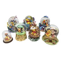 Five Disney Winnie The Pooh snow globes, to include Pooh and Piglet Sailing, Pooh's Grand Adventure and Blustery Day, together with The Walt Disney Classic Waterglobe collection globe and group Tigger, Winnie and Piglet figure under dome, all with boxes (7)