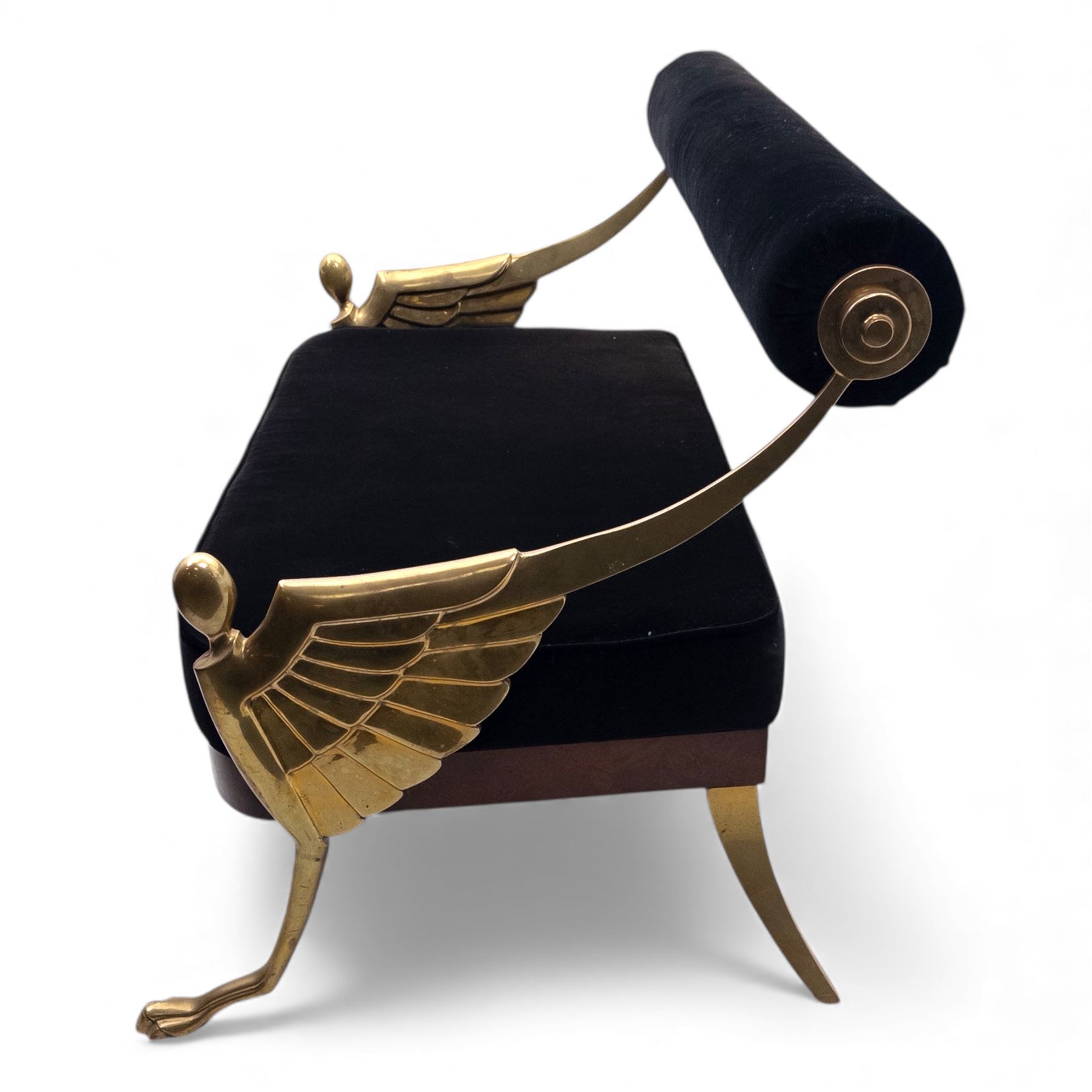 Late 20th century pair of Empire inspired brass metal framed two-seater sofas, upholstered in black velvet with cylindrical backrest and sphinx form arms terminating in paw feet, together with matching deep buttoned black velvet footstool on brass capped legs (Footstool H 38cm, W 70cm, D 70cm)