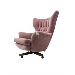 Paul Conti for G-Plan - 'Blofeld' Model 6250 swivel wingback armchair, upholstered in pink velour button back fabric, on teak base with castors