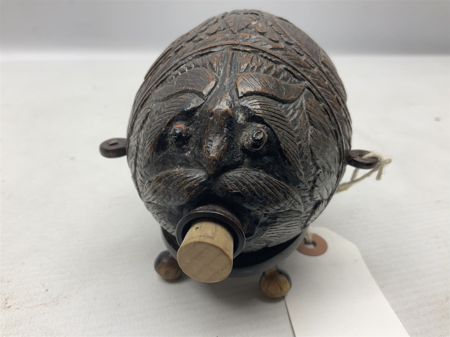 19th century bug bear flask carved with Balkan figures, a wolf and leafage with glass eyes, L14cm on stand 