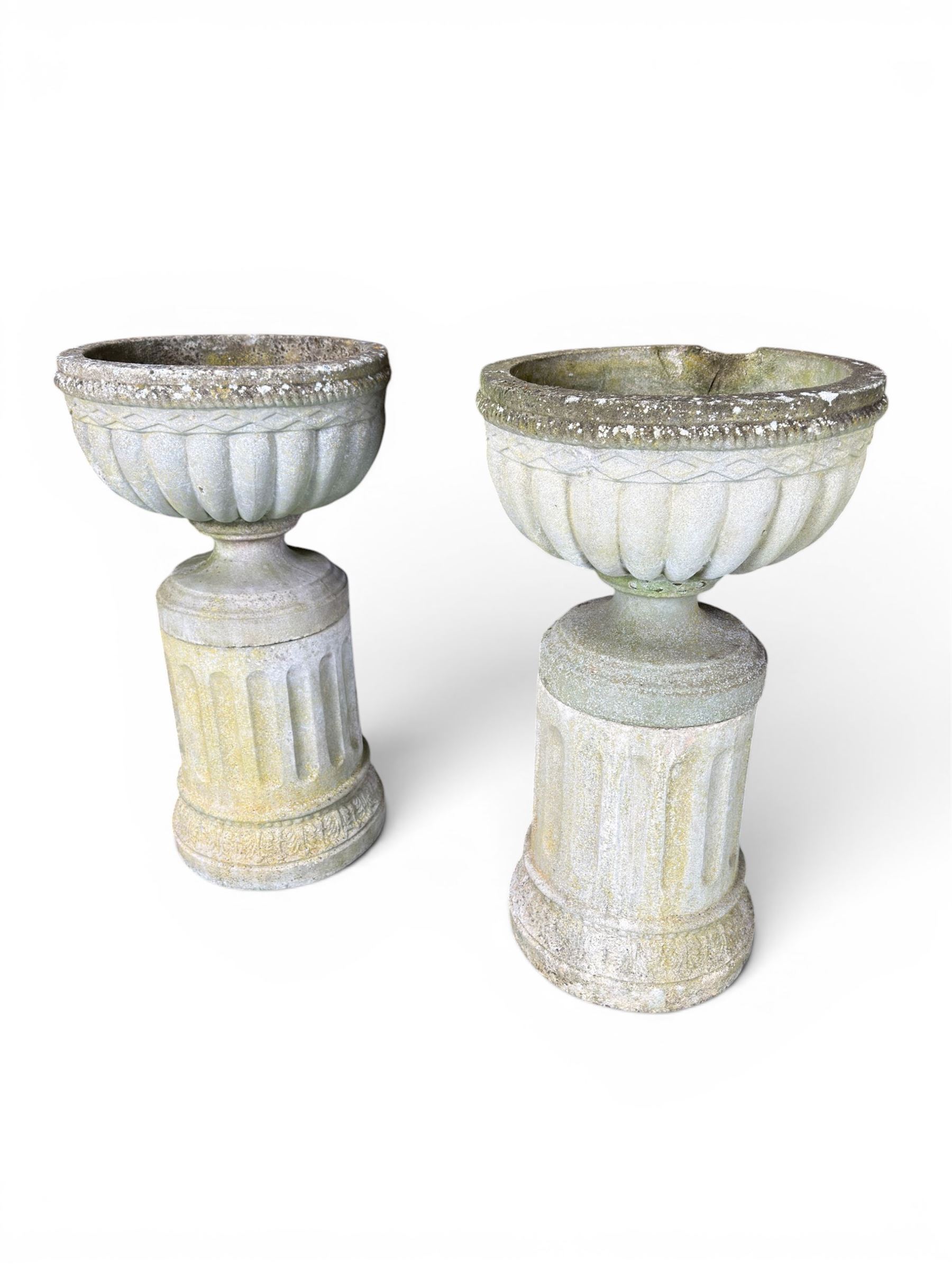Four 20th century good quality weathered cast stone pedestal urns, circular lobed bowls with rope twist and lattice border, raised on squat base with fluted columns