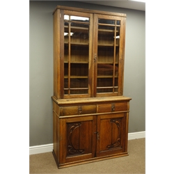  Art Nouveau oak bookcase with two glazed doors, above two drawers with brass ring handles and two doors carved with stylised foliage, W107cm, H210cm, D49cm  