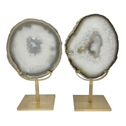 Pair of white agate slices, polished with rough edges raised upon gilt metal stands, H24cm