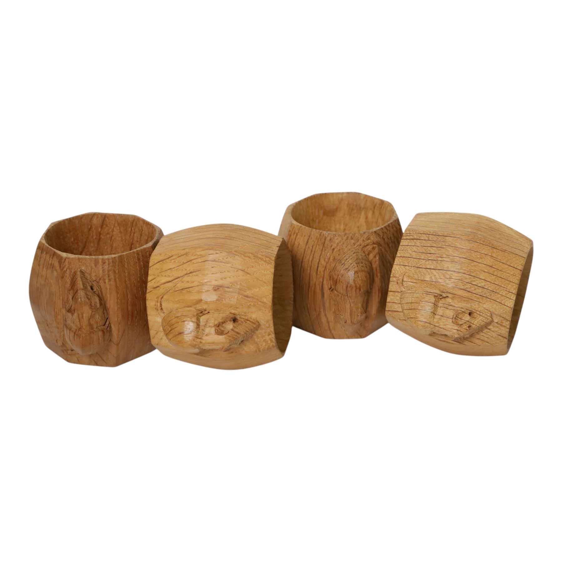 Mouseman - four light oak napkin rings, of bulbous octagonal form with signature mouse carving by Robert Thompson of Kilburn