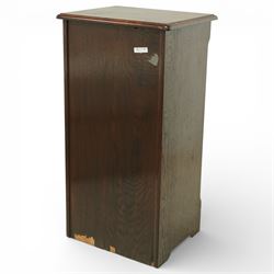 Early 20th century oak filing cabinet, the rectangular top with moulded edge above a tambour shutter enclosing a fitted interior with eleven shaped filing shelves, the sides with shaped uprights, raised on a plinth base