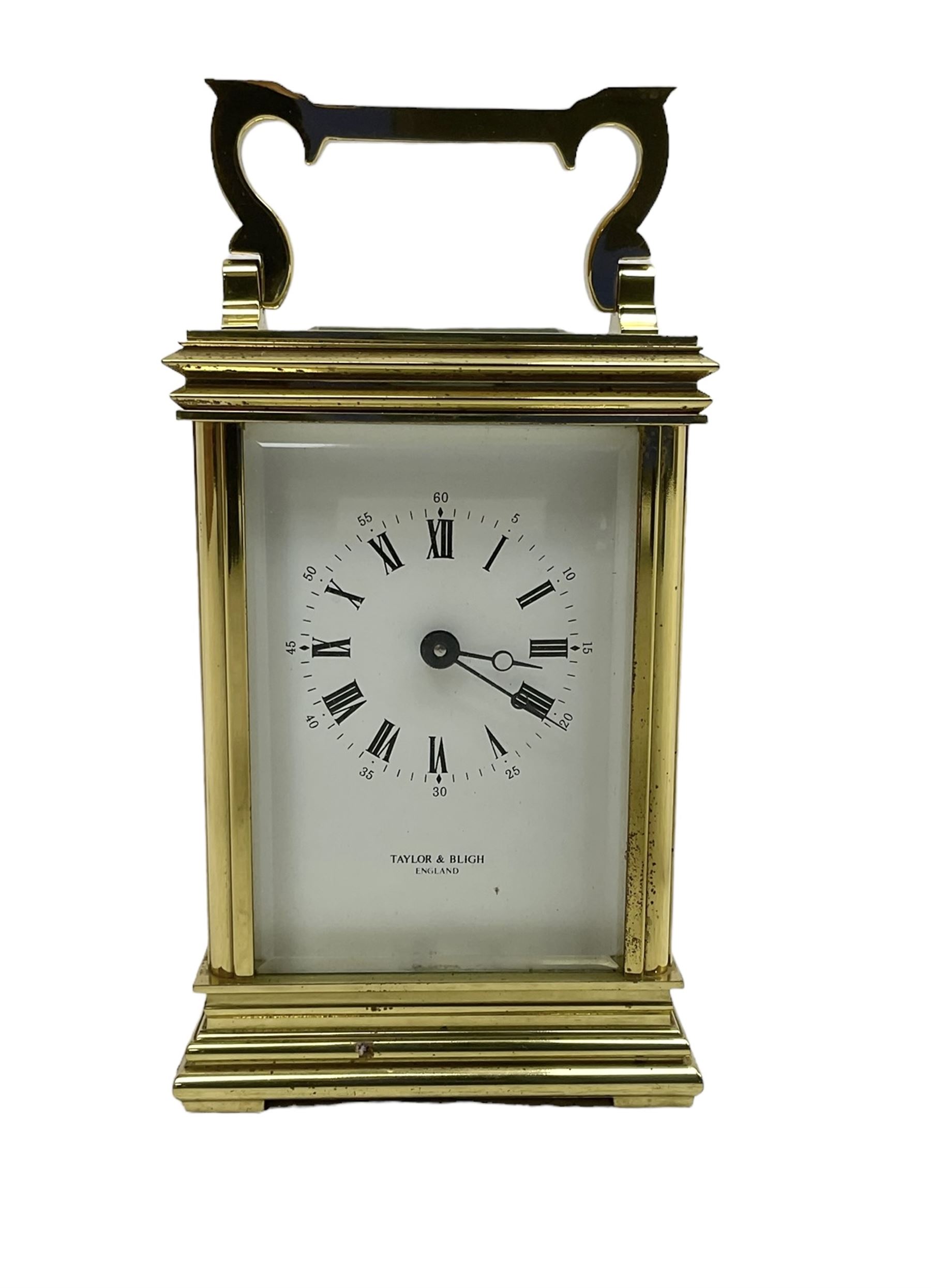 English - late 20th century 8-day carriage clock by Taylor & Bligh, in an Anglaise case with a rectangular handle, bevelled glass panels and enamel dial with Roman numerals, minute markers and steel moon hands, timepiece spring driven movement with a jewelled lever platform escapement. With key.