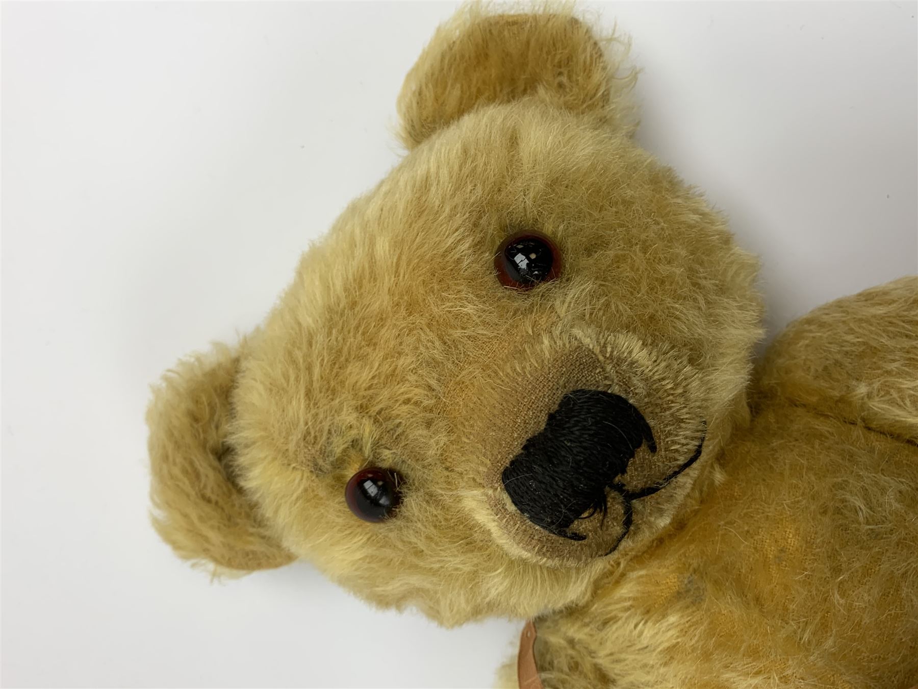 Merrythought Hygienic Toys large 'Magnet' teddy bear c1930s with plush body, swivel jointed head with glass eyes and vertically stitched nose and mouth and jointed limbs,  celluloid wishbone button to right ear and stitched label under right pad H22