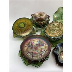 A collection of Carnival glass, to include marigold, green, and amethyst, bowls, dishes, and comports, various patterns including fruiting vines, peacocks, and an example decorated with a Horseshoe and detailed Good Luck. 
