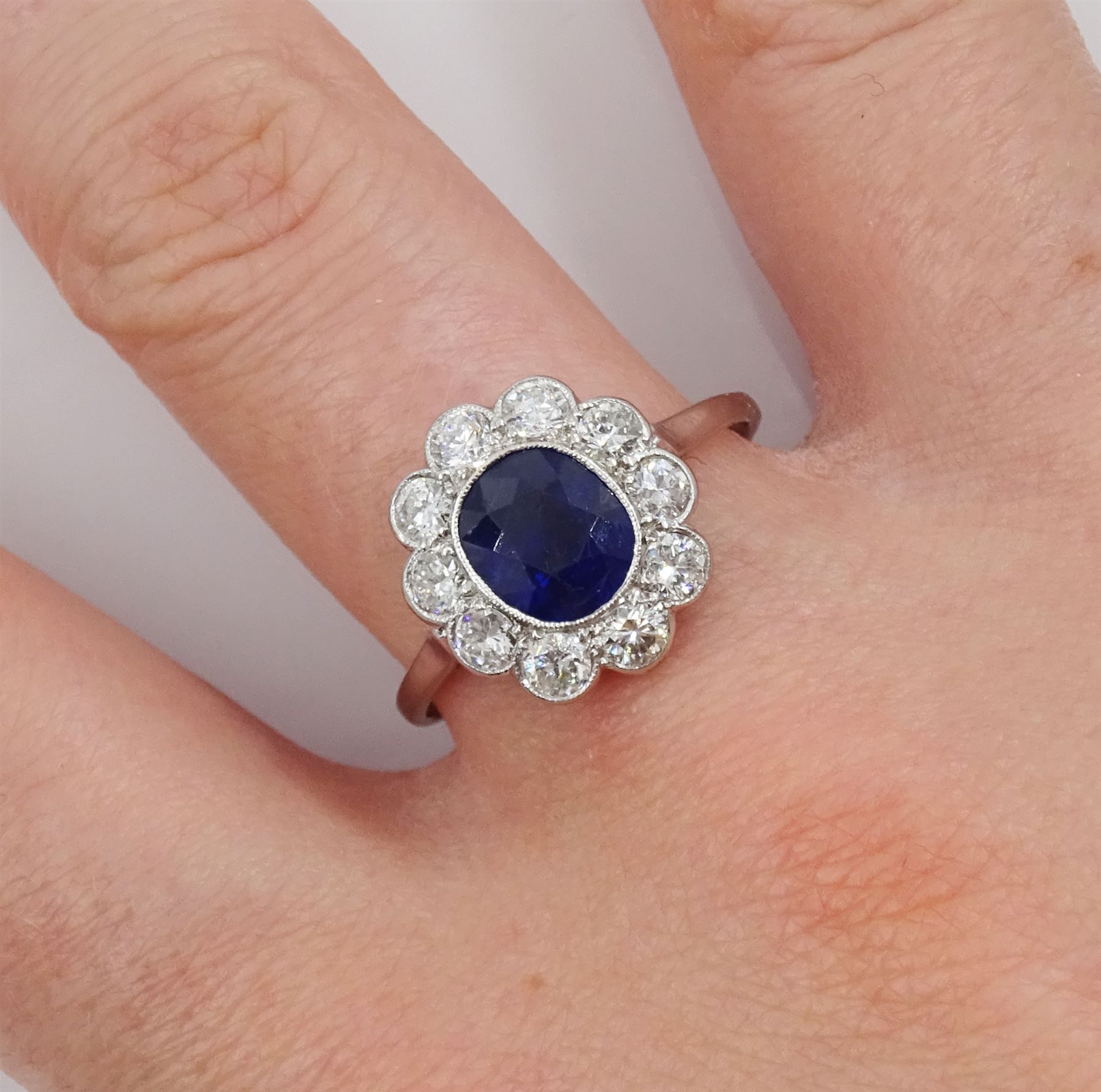 Palladium and platinum milgrain set oval sapphire and diamond cluster ring, sapphire approx 1.35 carat, total diamond weight approx 0.55 carat