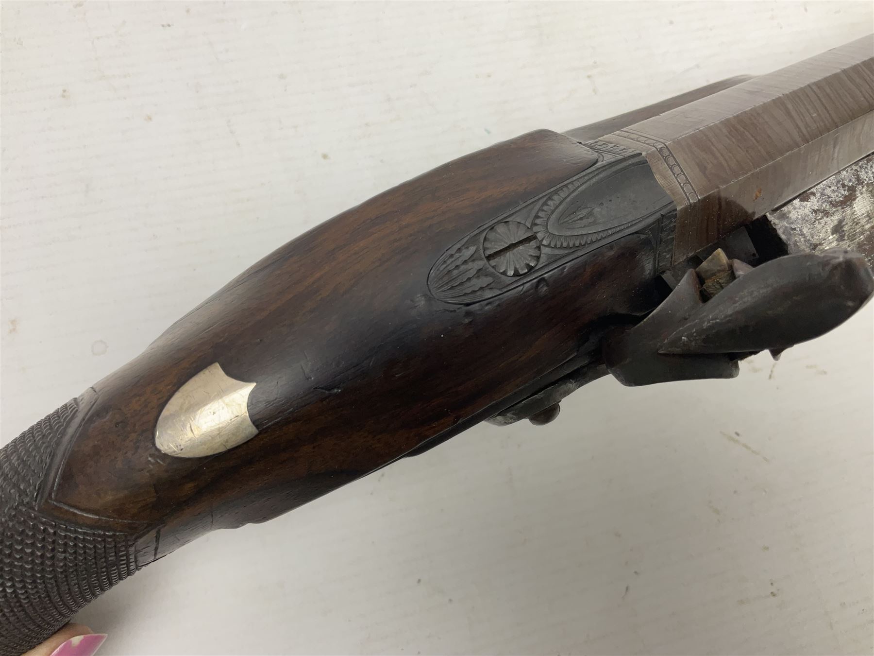 Early 19th century 16-bore flintlock single barrel travelling pistol, the 21.5cm stub twist octagonal barrel with two barrel pins and ramrod under, engraved lock plate with roller frizzen, engraved trigger guard with pineapple finial, walnut stoock with chequered grip L40cm overall