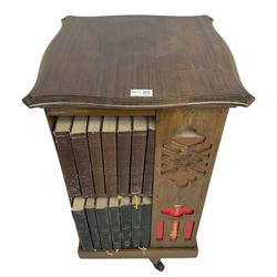 Late Victorian revolving bookcase, shaped square top over fretwork supports of geometric and arcade design, on a swivel action base with ceramic castors